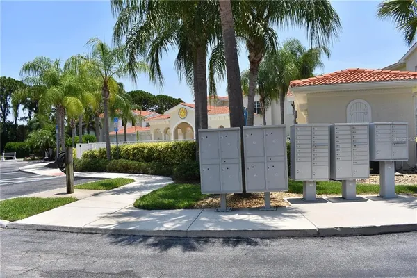 a view of a house with a yard and palm trees