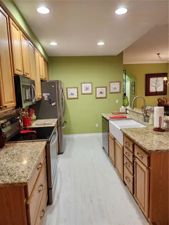 a kitchen with stainless steel appliances granite countertop a sink stove and refrigerator