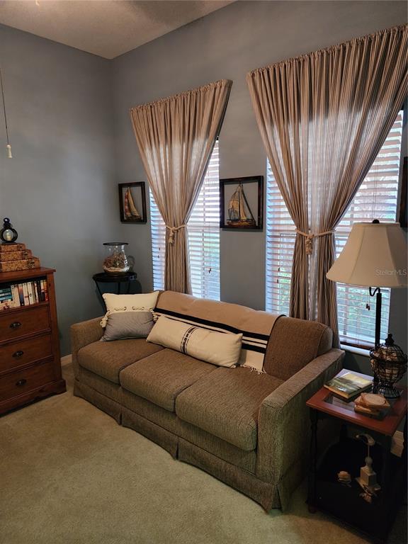 400 Ravinia Circle, Unit 400 Venice, FL 34292 - Photo 10 of 31 a living room with furniture a bookshelf and a window