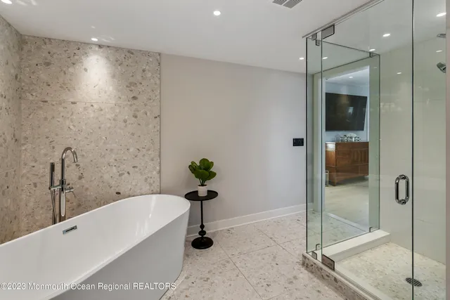 a bathroom with a tub shower and mirror