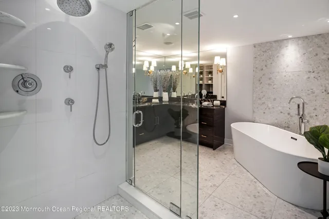 a bathroom with a tub a double vanity sink a mirror a shower and a bathtub