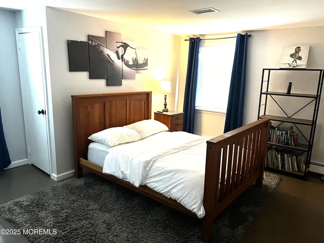 a bed sitting in a bedroom next to a window with pc on the table