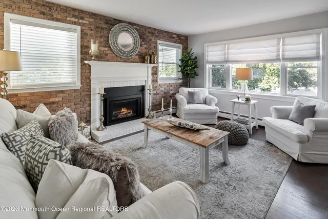 a living room with furniture a large window and a fireplace