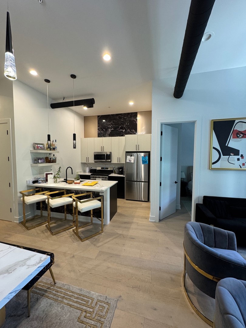 77 West Chestnut Street, Unit 3B Chicago, IL 60610 - Photo 2 of 14 a living room with furniture and a kitchen view