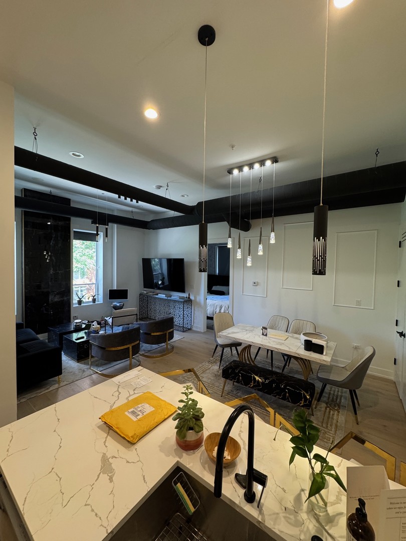 77 West Chestnut Street, Unit 3B Chicago, IL 60610 - Photo 5 of 14 a living room with furniture a flat screen tv and a table