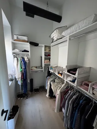 a view of walk in closet with clothes and shoes