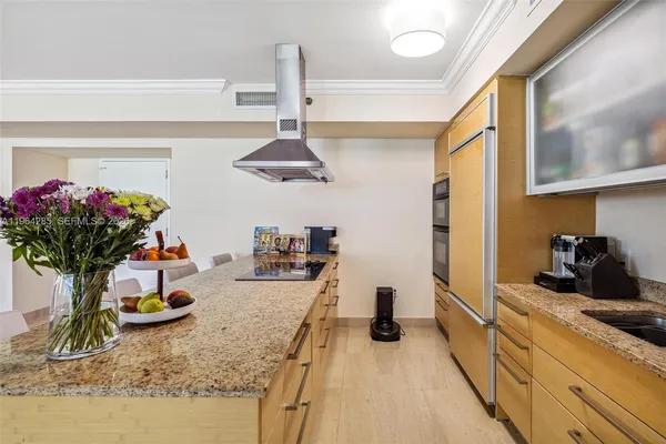 a kitchen with a refrigerator and potted plant