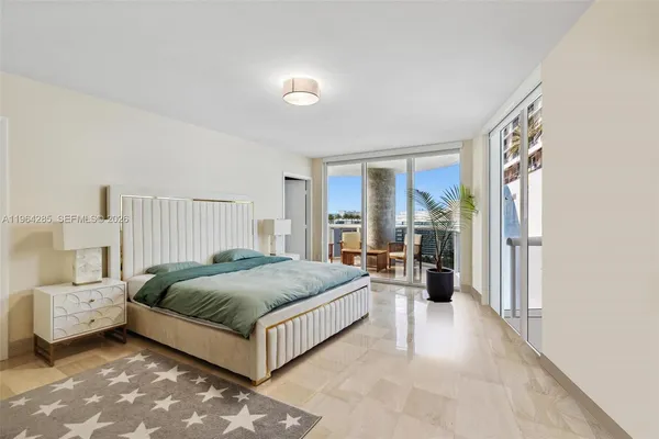 a spacious bedroom with a bed and a large window