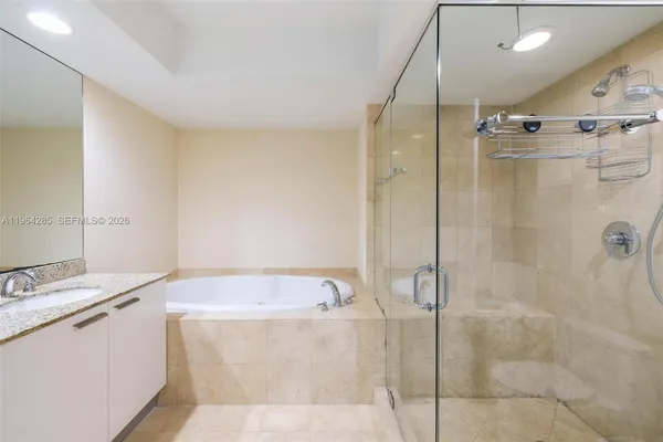 a bathroom with a granite countertop sink a mirror and shower
