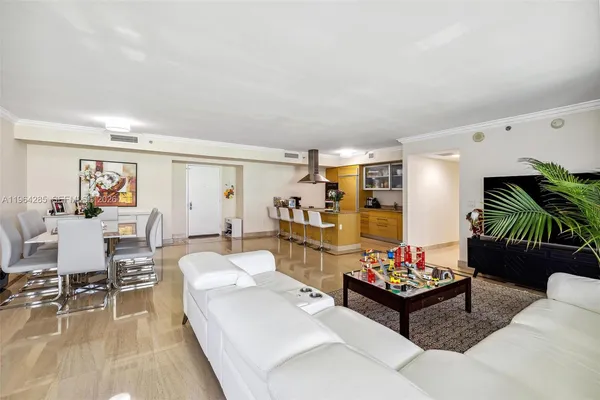 a living room with furniture and view of kitchen