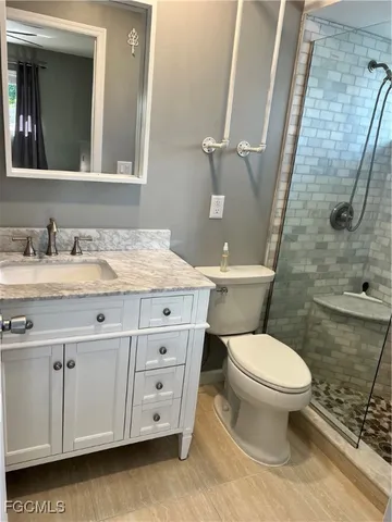 a bathroom with a granite countertop toilet sink and mirror