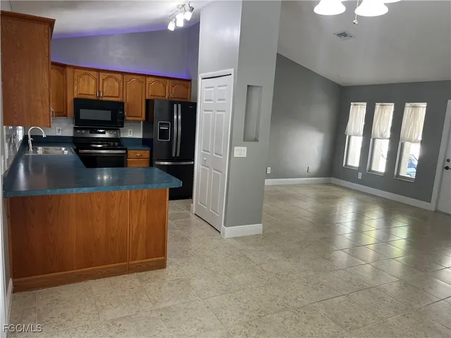 a kitchen with stainless steel appliances a refrigerator and a stove top oven