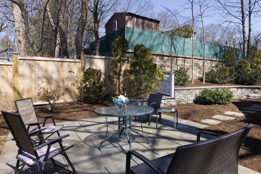 208 South Street Brookline, MA 02467 - Photo 28 of 30 a view of a patio with table and chairs with wooden fence and plants