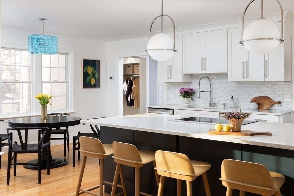208 South Street Brookline, MA 02467 - Photo 5 of 30 a kitchen with stainless steel appliances a dining table chairs and a refrigerator