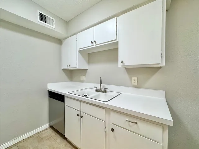 a kitchen with a sink cabinets and a wooden floor