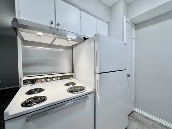 a white refrigerator freezer and a stove sitting inside of a kitchen
