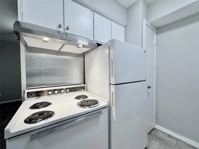 a white refrigerator freezer and a stove sitting inside of a kitchen