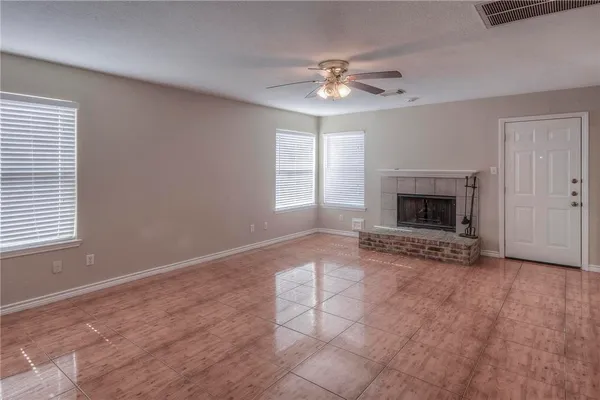 an empty room with windows and fireplace