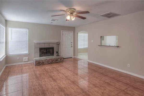 a view of an empty room with window and a fireplace