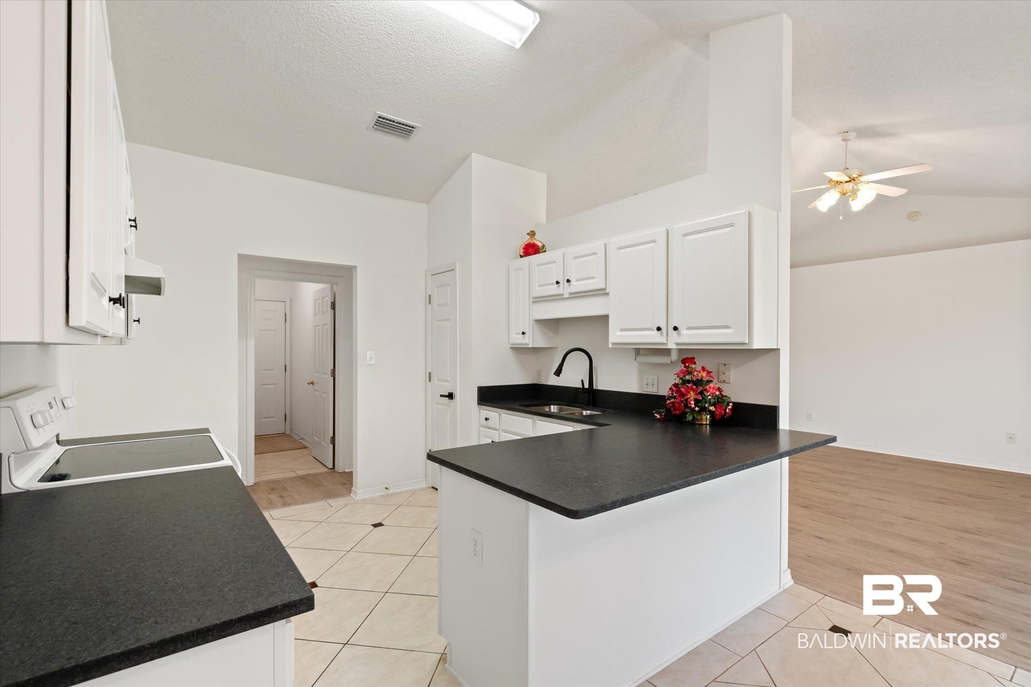 12520 Hunters Chase Foley, AL 36535 - Photo 20 of 32 Kitchen with white range with electric cooktop, light tile patterned floors, dark countertops, and a sink