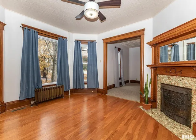 a view of an empty room with window and fire place