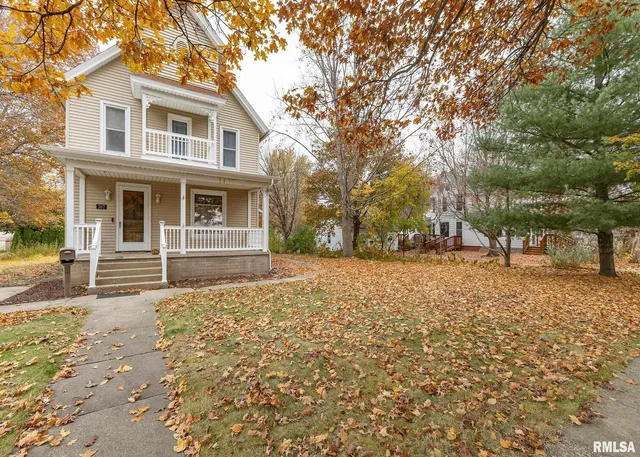 a front view of a house with a yard covered with snow
