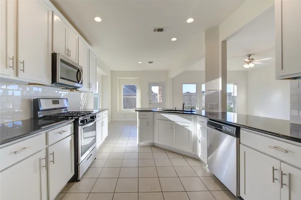 a view of an empty room with a chandelier fan