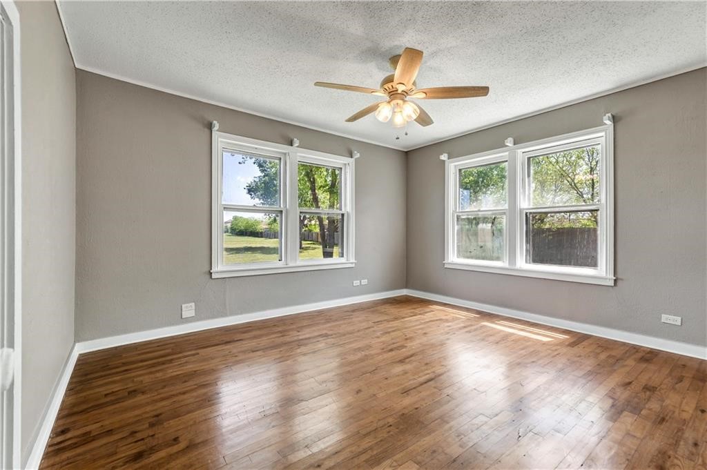 211 Tate Lane Round Rock, TX 78665 - Photo 13 of 40 a view of an empty room with wooden floor and a window