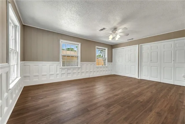 a view of a room with a large window and wooden floor