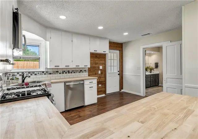 a kitchen with stainless steel appliances granite countertop a stove sink and cabinets