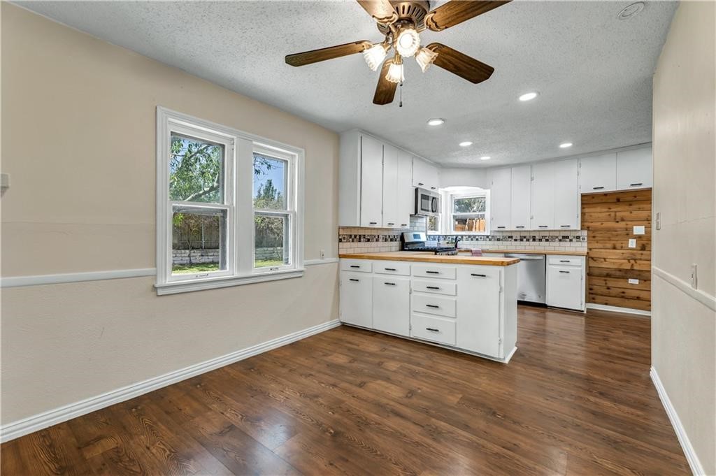 211 Tate Lane Round Rock, TX 78665 - Photo 21 of 40 a kitchen with a stove a sink and white cabinets