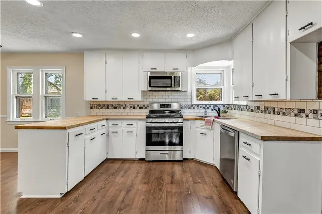 a kitchen with granite countertop a stove top oven sink and cabinets