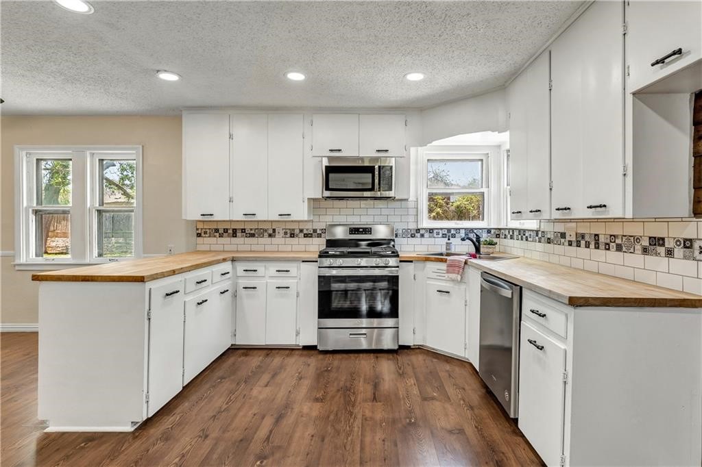 211 Tate Lane Round Rock, TX 78665 - Photo 4 of 40 a kitchen with granite countertop a stove top oven sink and cabinets