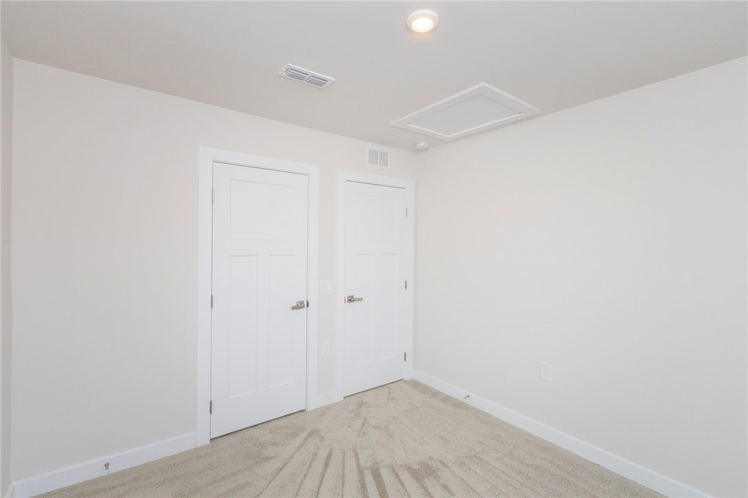 233 Scenic Road Anderson, SC 29621 - Photo 43 of 50 A well-lit interior space featuring two white paneled doors and soft, neutral carpeting.
