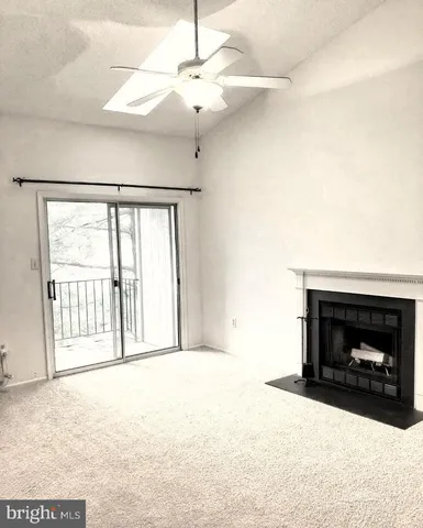 a view of an empty room with a fireplace and a window