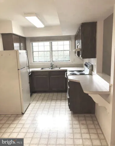 a kitchen with stainless steel appliances granite countertop a sink and a refrigerator