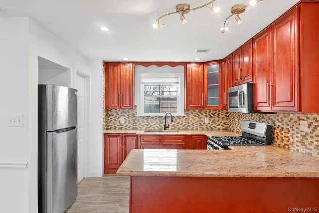 a kitchen with stainless steel appliances granite countertop a refrigerator and a sink