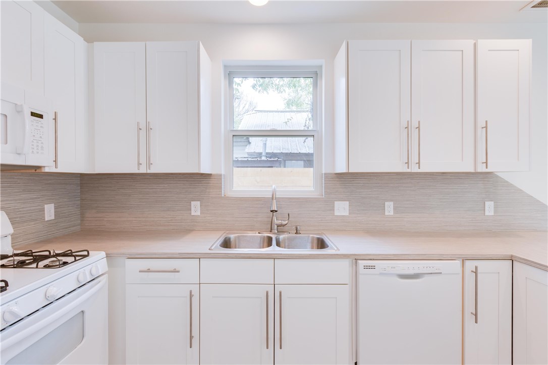 1906 East 17th Street, Unit 1 Austin, TX 78702 - Photo 16 of 33 a kitchen with white cabinets and a stove top oven