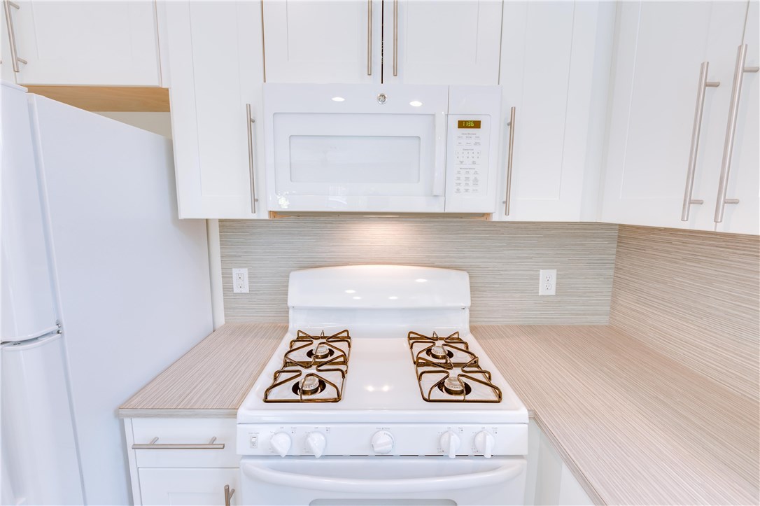1906 East 17th Street, Unit 1 Austin, TX 78702 - Photo 18 of 33 a kitchen with a stove and white cabinets