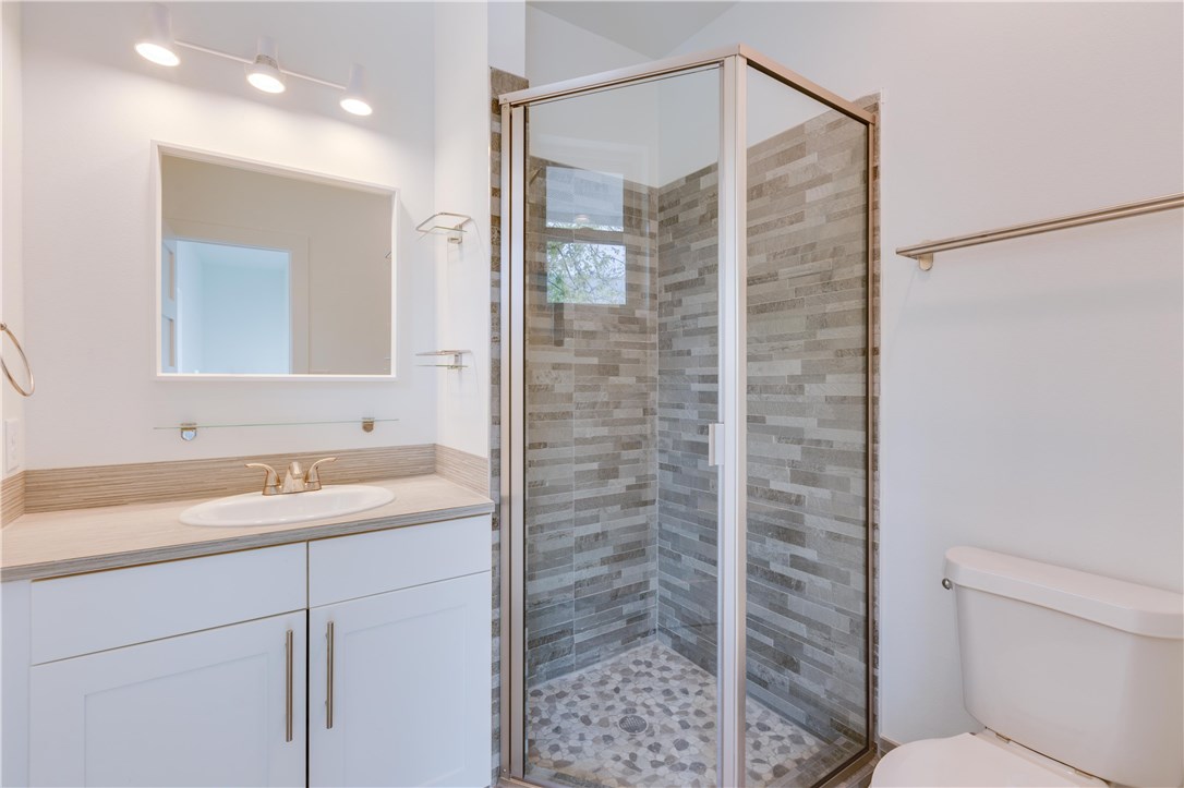 1906 East 17th Street, Unit 1 Austin, TX 78702 - Photo 23 of 33 a bathroom with a granite countertop sink a toilet and shower