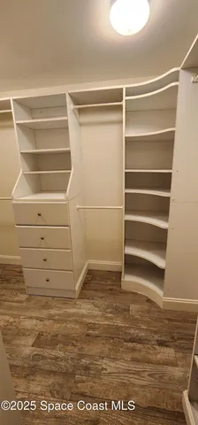 a view of walk in closet with empty racks