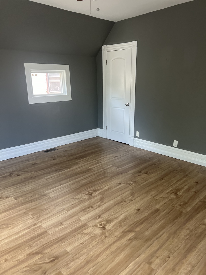12124 South Normal Avenue Chicago, IL 60628 - Photo 16 of 36 a view of an empty room with wooden floor and a window