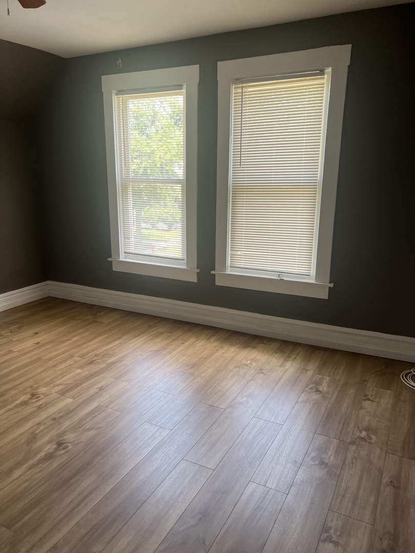 12124 South Normal Avenue Chicago, IL 60628 - Photo 19 of 36 a view of an empty room with wooden floor and a window