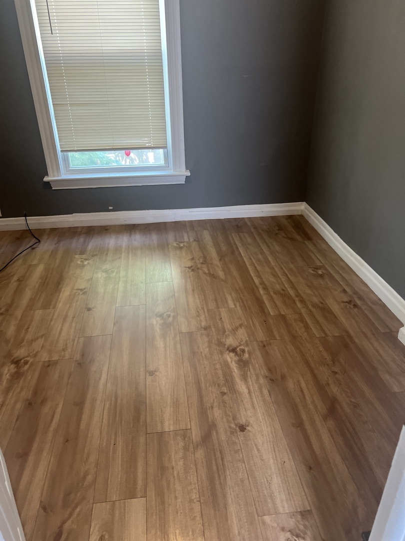12124 South Normal Avenue Chicago, IL 60628 - Photo 22 of 36 a view of empty room with wooden floor and fan