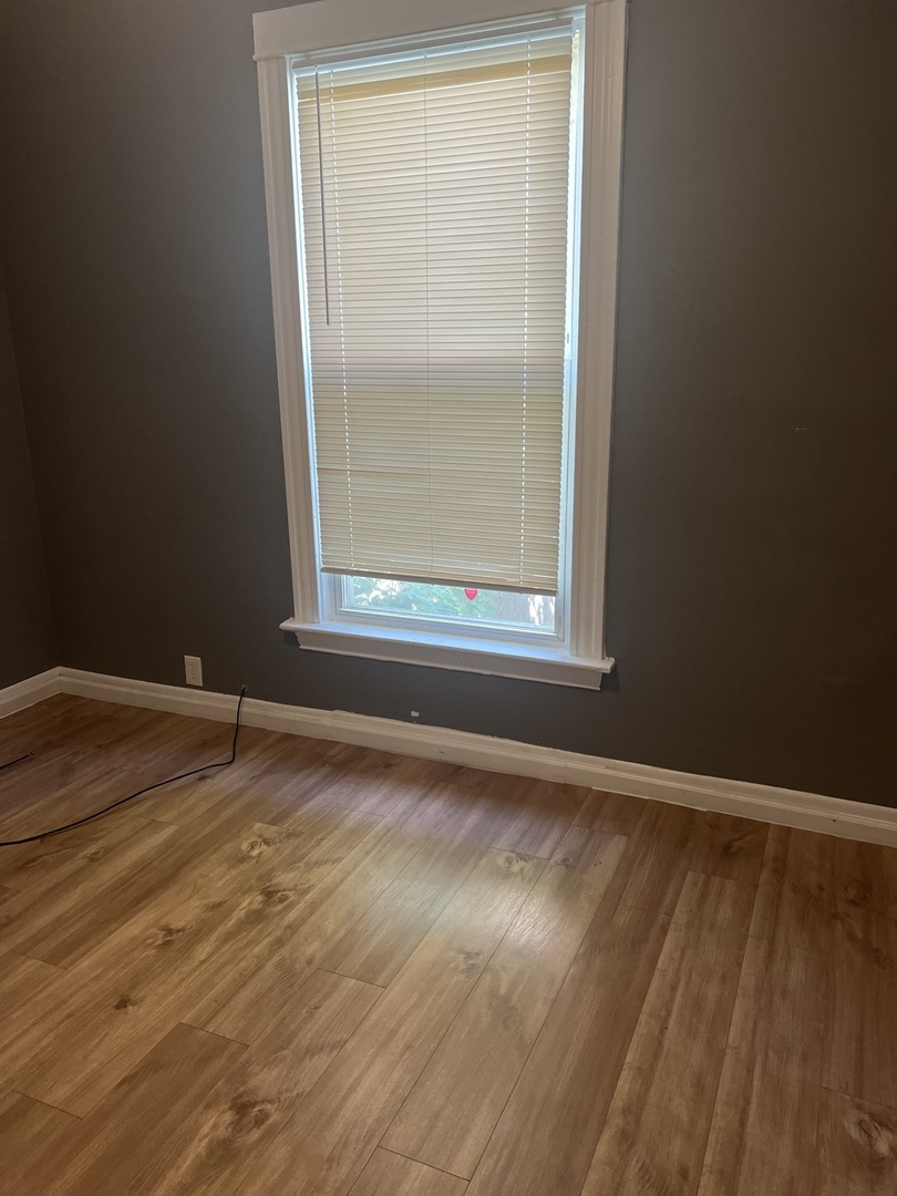 12124 South Normal Avenue Chicago, IL 60628 - Photo 26 of 36 a view of a room with wooden floor and a window