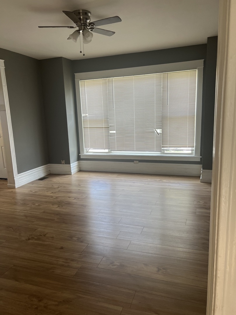 12124 South Normal Avenue Chicago, IL 60628 - Photo 4 of 36 a view of empty room with wooden floor and fan