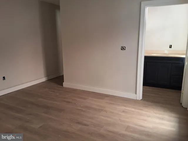 an empty room with wooden floor and cabinet