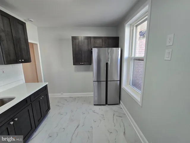 a kitchen with a refrigerator a sink and a stove top oven