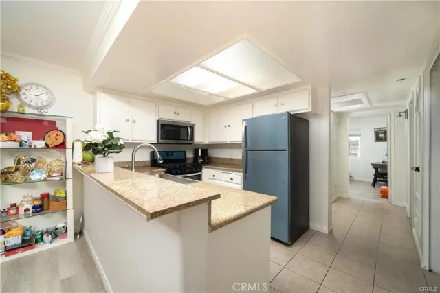 a kitchen with stainless steel appliances a refrigerator sink and microwave