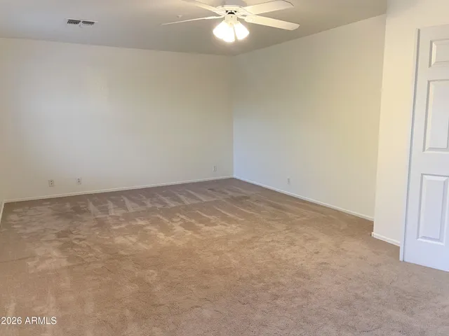 an empty room with a chandelier fan